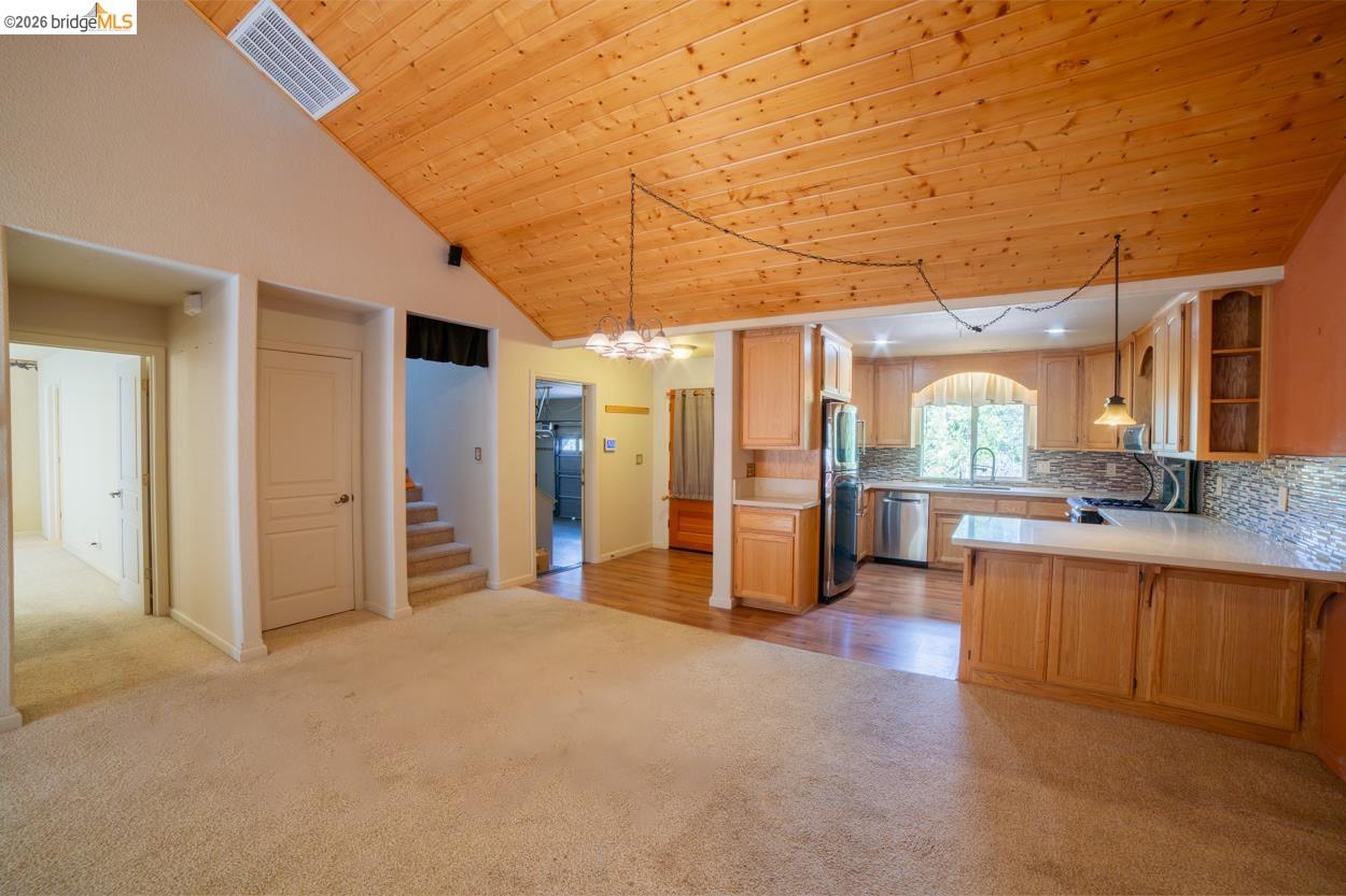22401 Ridge Road Twain Harte, CA 95383 - Photo 17 of 52 Vaulted wood-paneled ceiling, kitchen with stainless steel appliances, light wood cabinetry, white countertops, and a tile backsplash