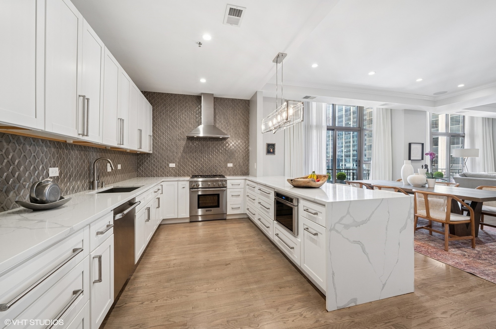 212 West Washington Street, Unit 1807 Chicago, IL 60606 - Photo 3 of 24 a large kitchen with stainless steel appliances granite countertop a lot of counter space and a sink