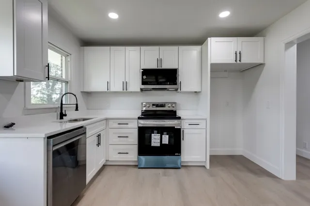 a kitchen with stainless steel appliances granite countertop a stove and a sink