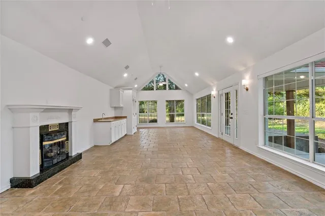 a view of an empty room with a fireplace and a window
