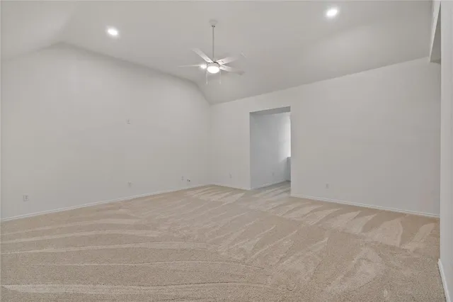 a view of an empty room with a chandelier fan