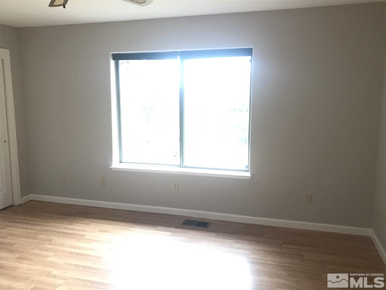 750 Buckeye Road Reno, NV 89521 - Photo 11 of 19 a view of an empty room with wooden floor and a window
