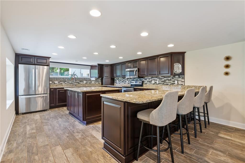 124 McBride Hill Road Butler, PA 16002 - Photo 20 of 41 a kitchen with stainless steel appliances granite countertop a table chairs sink and refrigerator