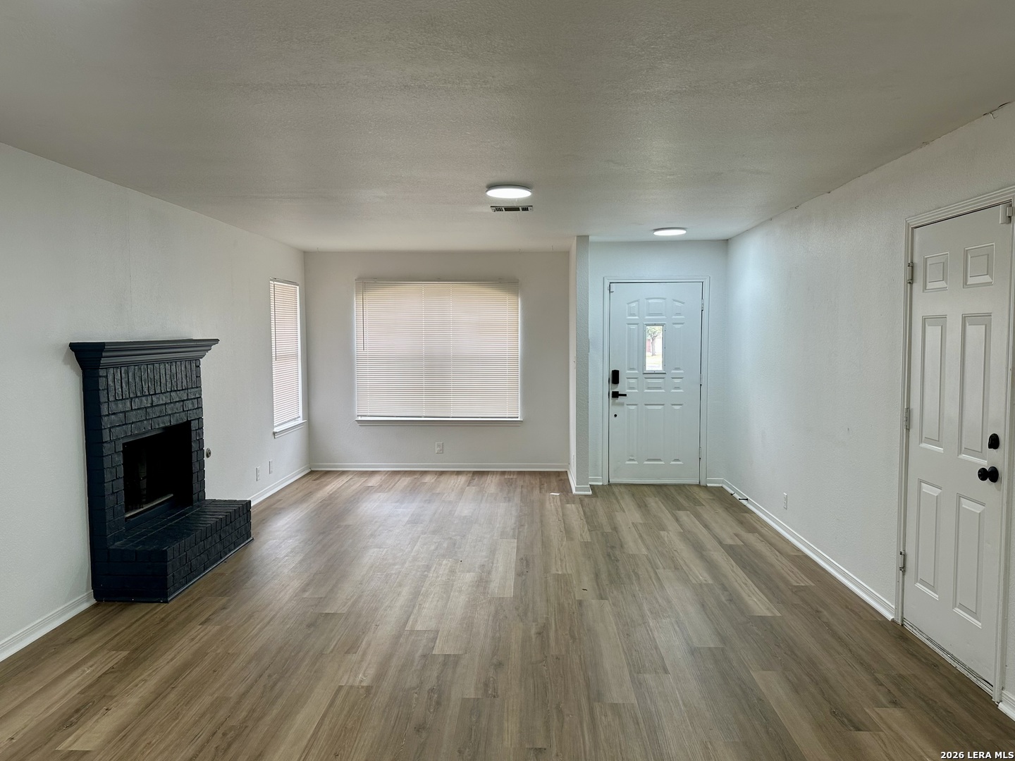 2012 Balsam Way Round Rock, TX 78665 - Photo 3 of 20 an empty room with wooden floor fireplace and windows