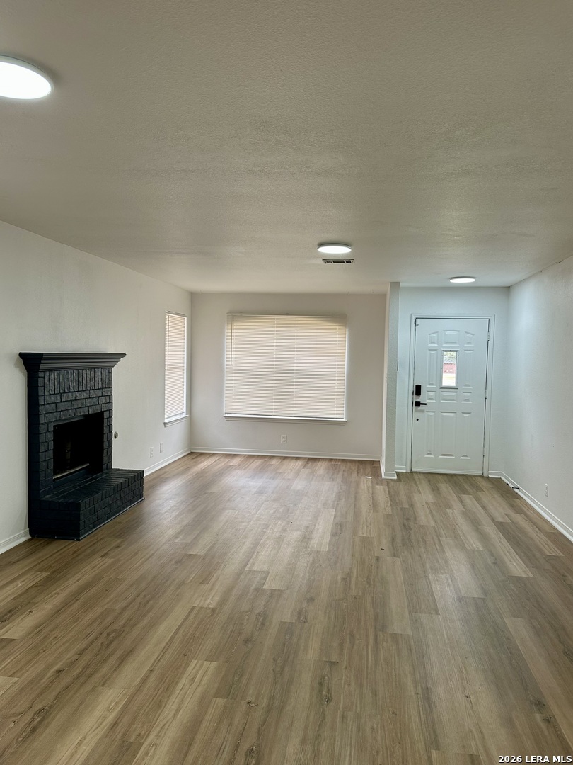 2012 Balsam Way Round Rock, TX 78665 - Photo 4 of 20 an empty room with wooden floor fireplace and windows
