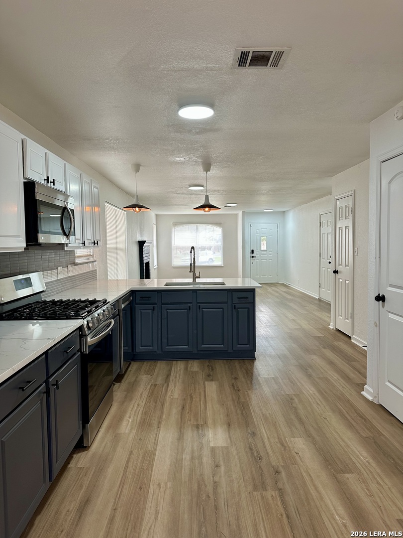 2012 Balsam Way Round Rock, TX 78665 - Photo 7 of 20 a large kitchen with wooden floors and stainless steel appliances