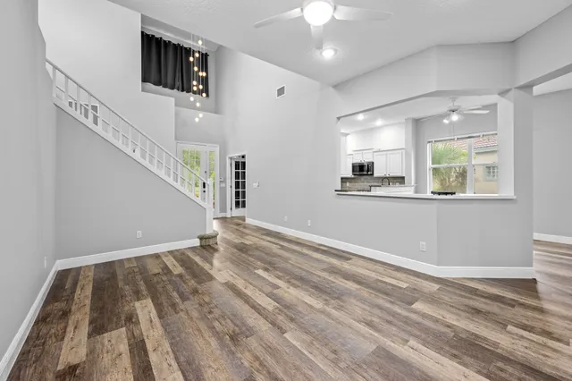 a view of kitchen with cabinets stainless steel appliances and wooden floor