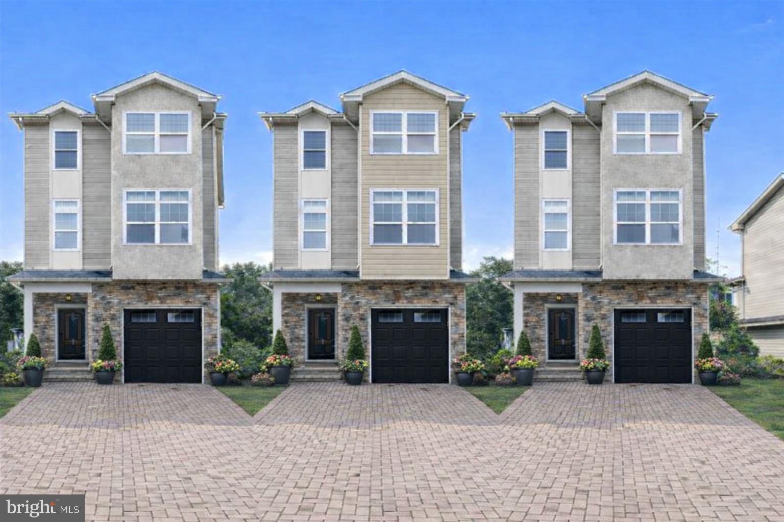 a front view of a house with yard and parking