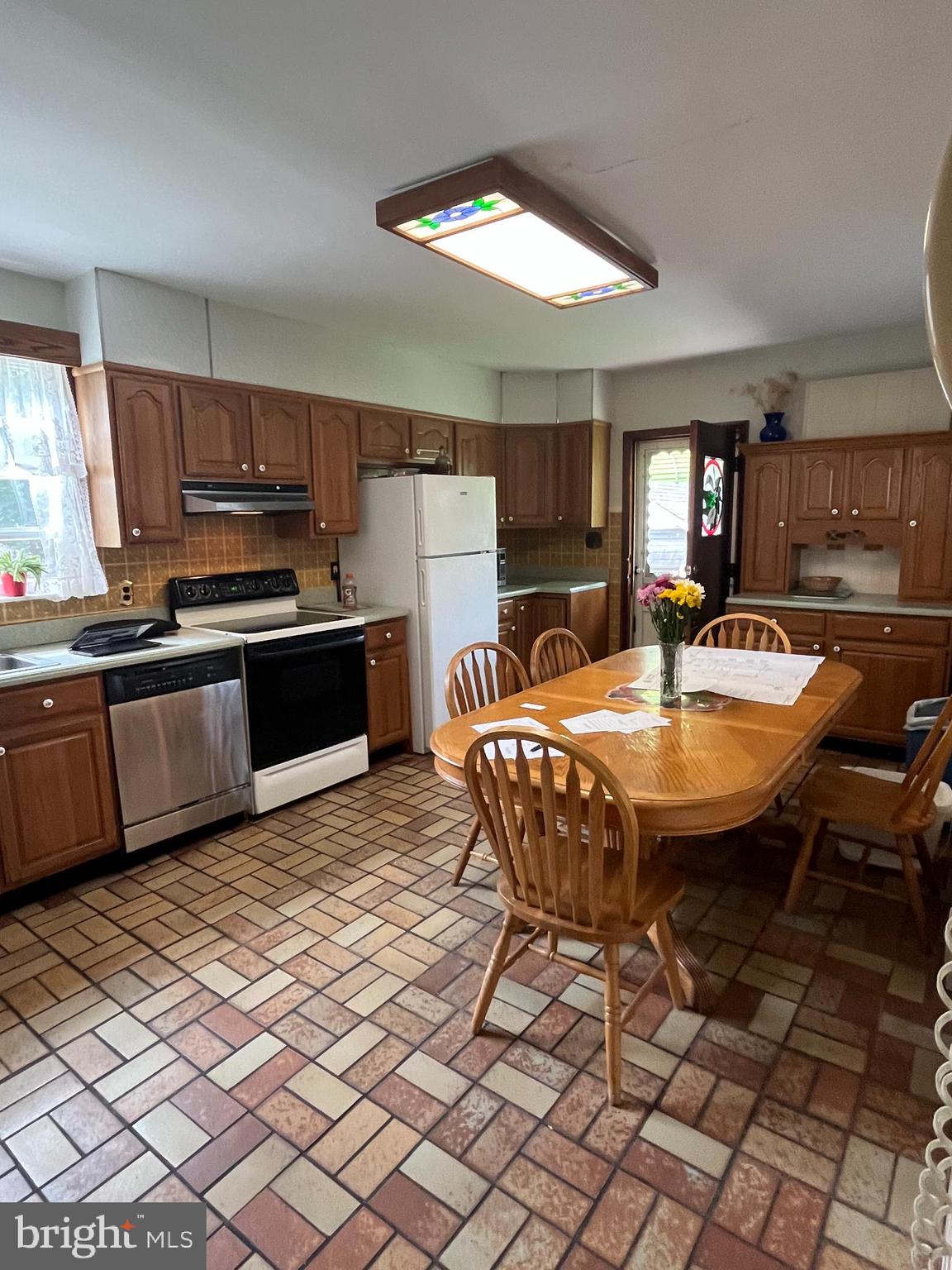 7514 Culp Street Philadelphia, PA 19128 - Photo 13 of 14 a kitchen with stainless steel appliances granite countertop a sink a stove a dining table and chairs