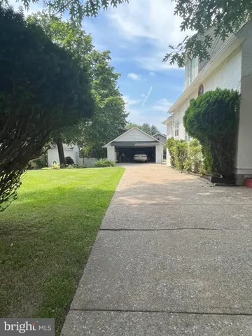 a view of a yard with plants and a bench