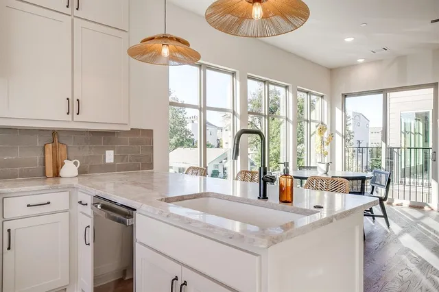 a kitchen with stainless steel appliances granite countertop a stove a sink and a granite counter tops with white cabinets