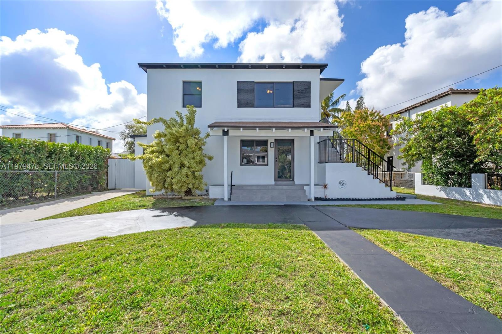 130 Southwest 31st Court, Unit 1 Miami, FL 33135 - Photo 1 of 17 a view of a house with a yard and table and chairs under an umbrella