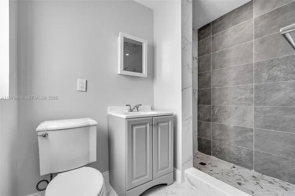 a bathroom with a toilet a sink and shower