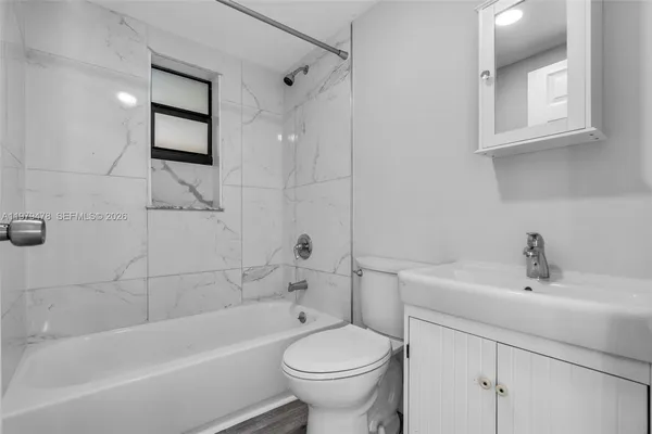 a white bath tub sitting next to a white toilet and sink