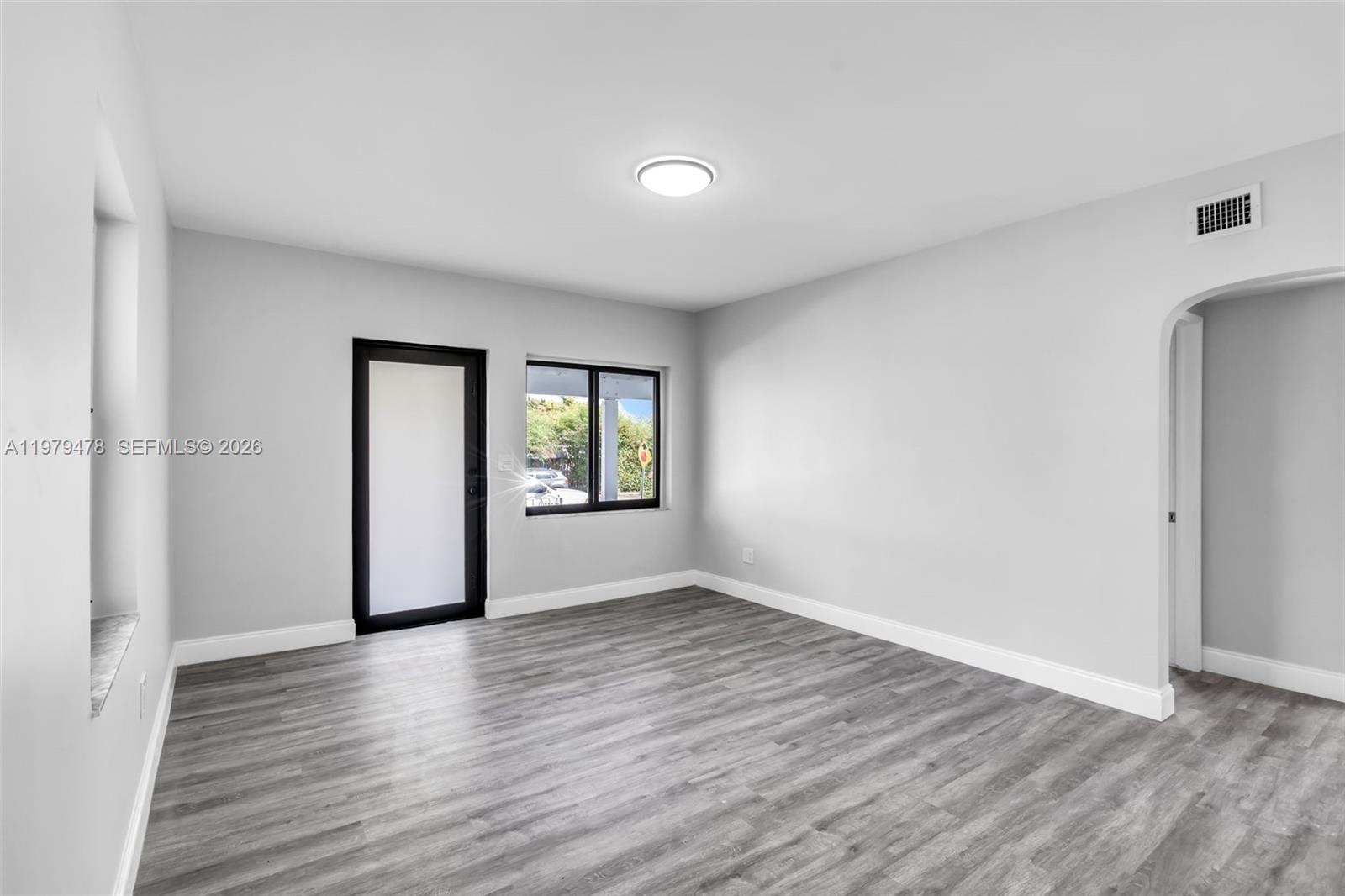 130 Southwest 31st Court, Unit 1 Miami, FL 33135 - Photo 3 of 17 a view of an empty room with window and wooden floor