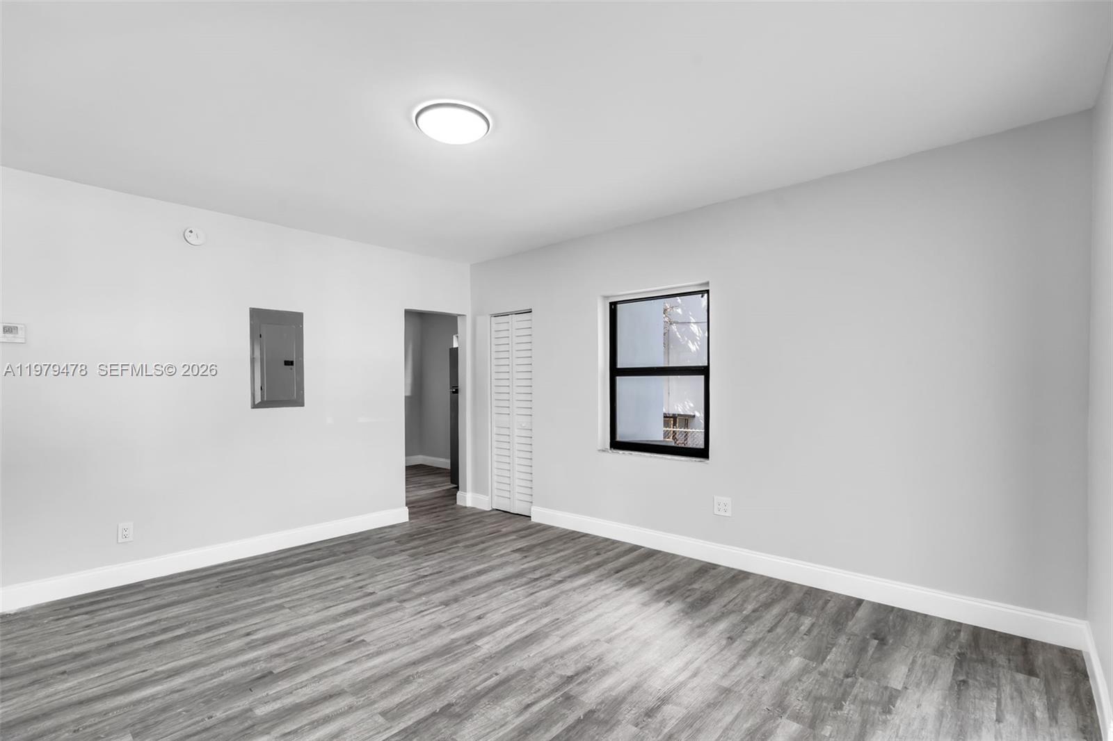 130 Southwest 31st Court, Unit 1 Miami, FL 33135 - Photo 5 of 17 an empty room with wooden floor and windows