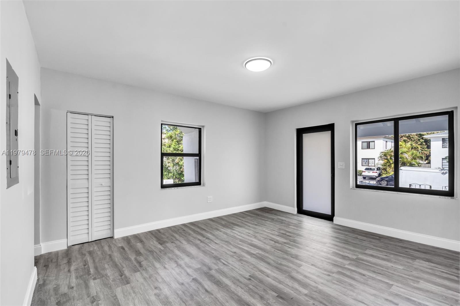 130 Southwest 31st Court, Unit 1 Miami, FL 33135 - Photo 6 of 17 an empty room with wooden floor and windows