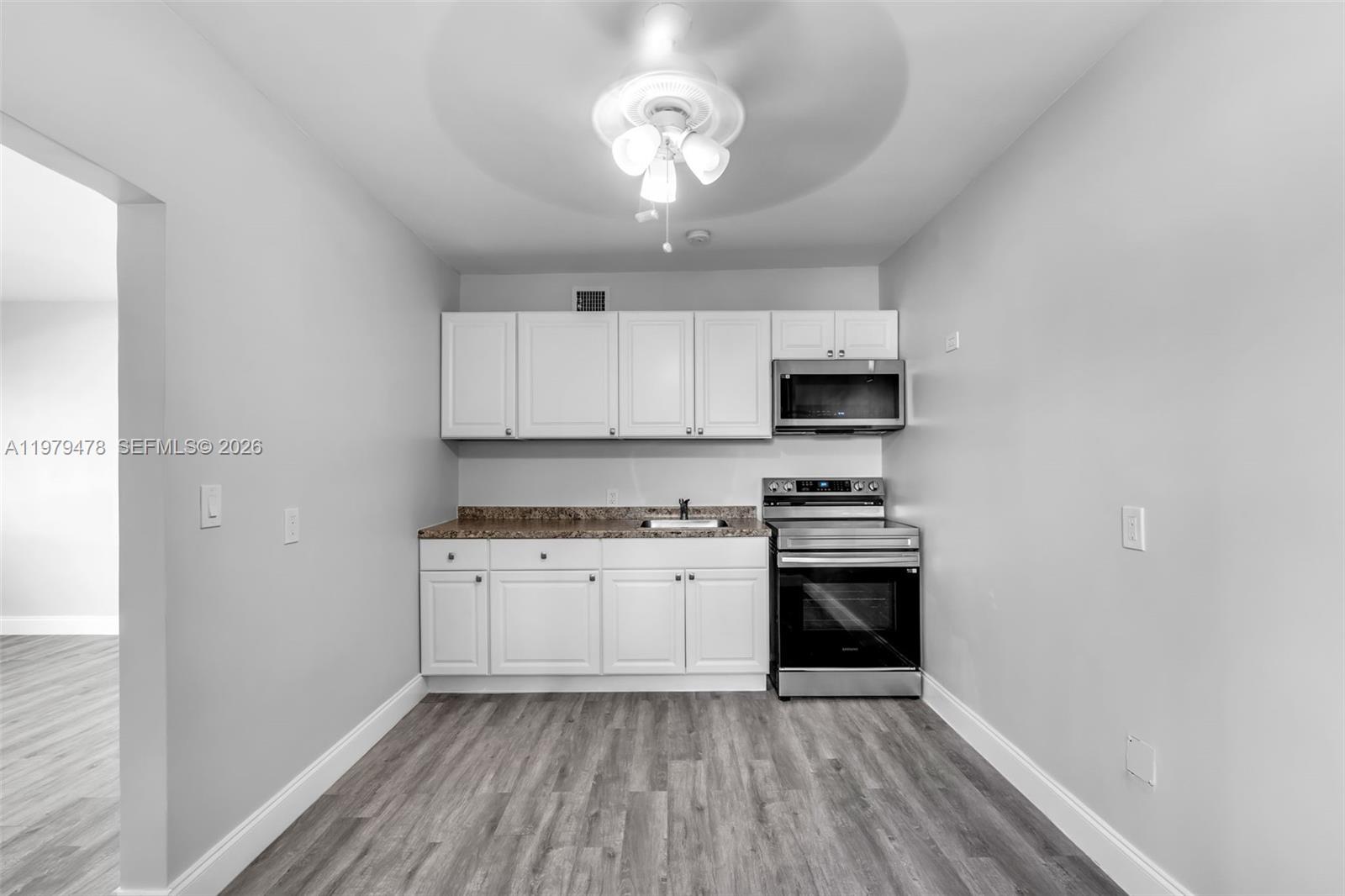 130 Southwest 31st Court, Unit 1 Miami, FL 33135 - Photo 7 of 17 a kitchen with granite countertop stainless steel appliances a stove microwave and cabinets