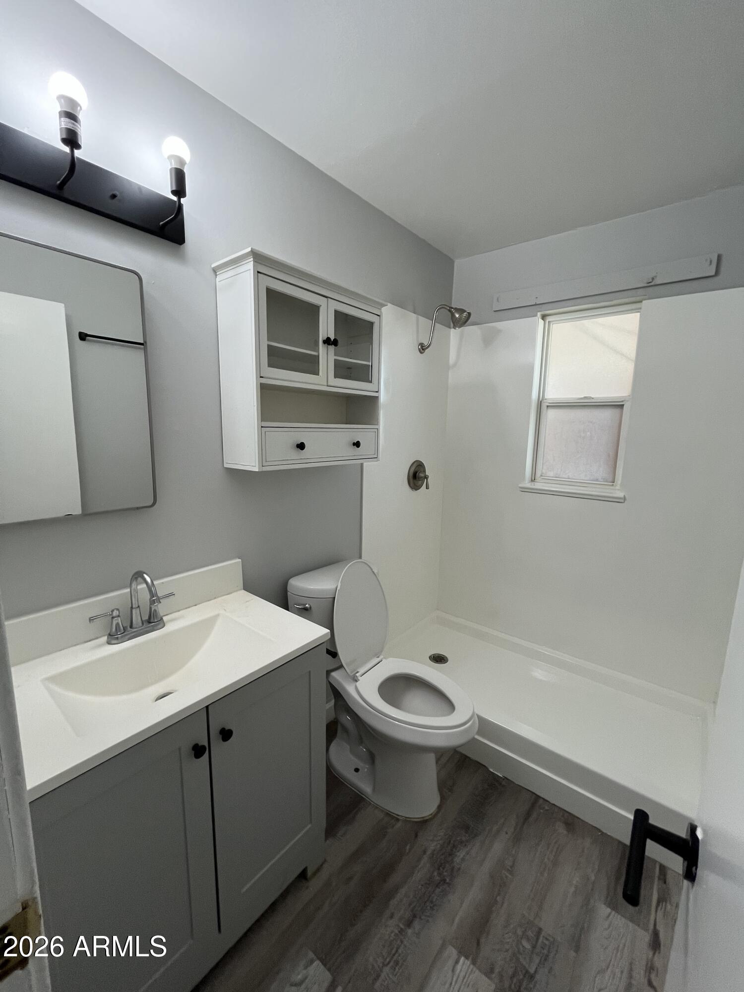 402 North 48th Street Phoenix, AZ 85008 - Photo 9 of 12 a bathroom with a sink toilet a mirror and shower