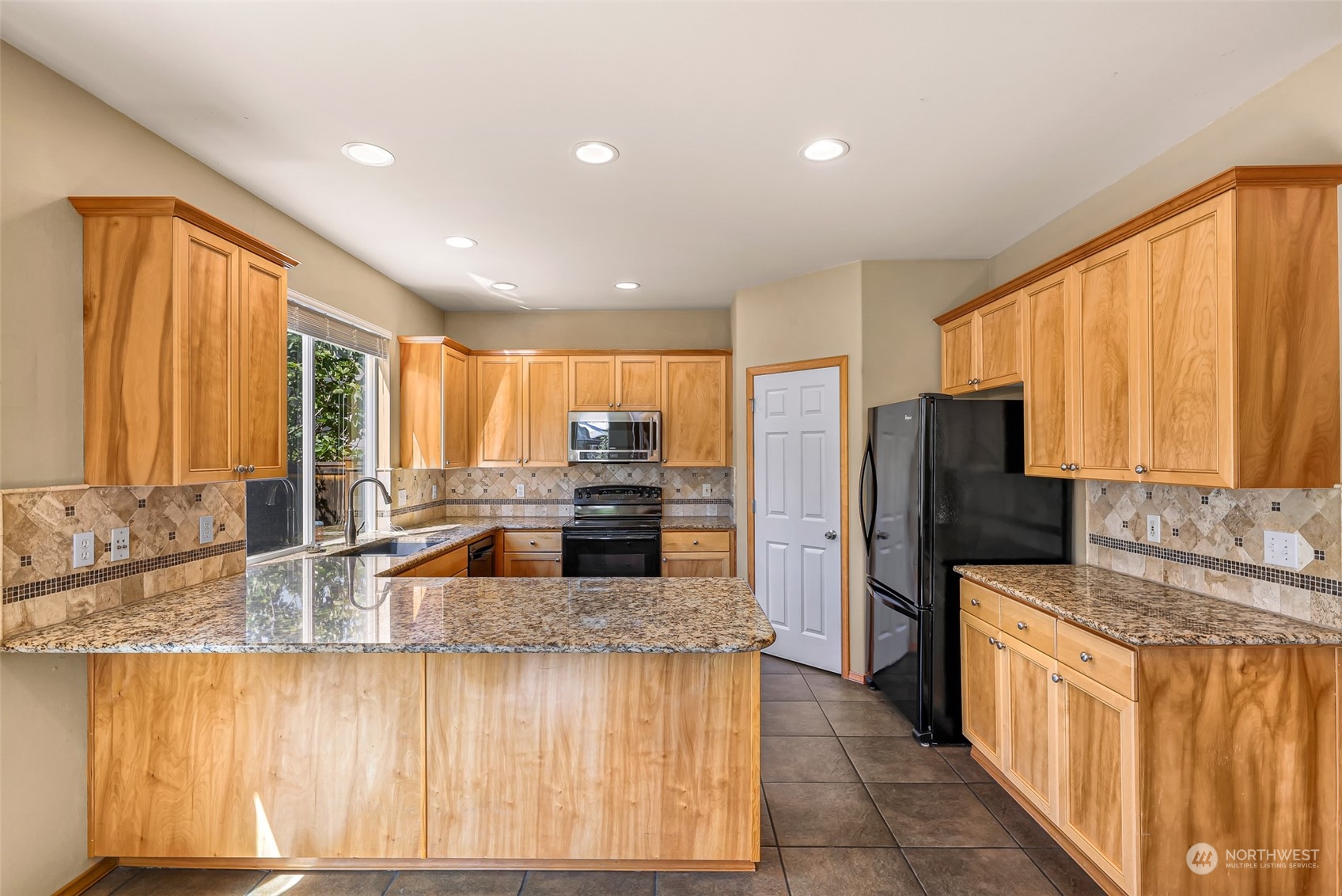 5907 Southeast 2nd Street Renton, WA 98059 - Photo 10 of 40 a kitchen with stainless steel appliances granite countertop a sink a stove and a refrigerator