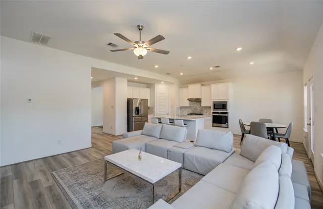 a living room with furniture and kitchen view