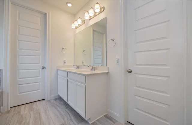 a bathroom with a sink vanity and a mirror