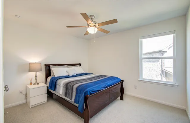 a bed sitting in a bedroom next to a window