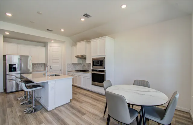 a kitchen with sink cabinets and wooden floor