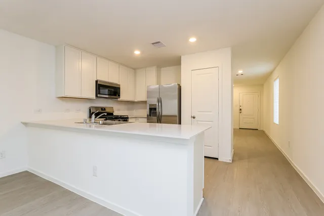 a kitchen with kitchen island a sink appliances and cabinets