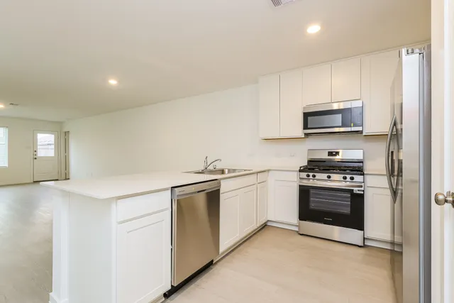 a kitchen with stainless steel appliances granite countertop a stove and a sink