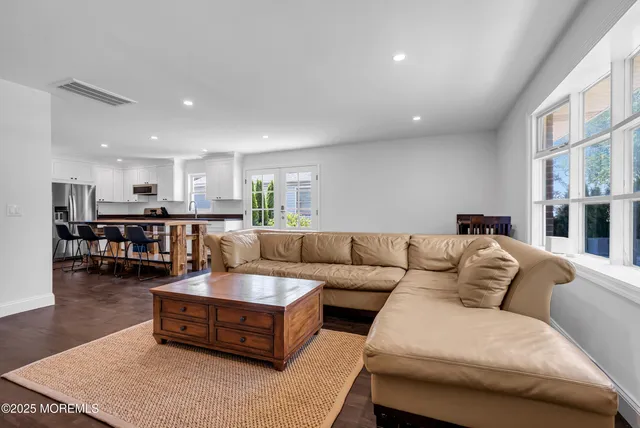 a living room with furniture and view of kitchen