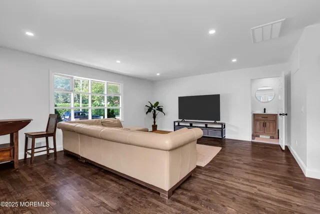 a living room with furniture flat screen tv and a large window