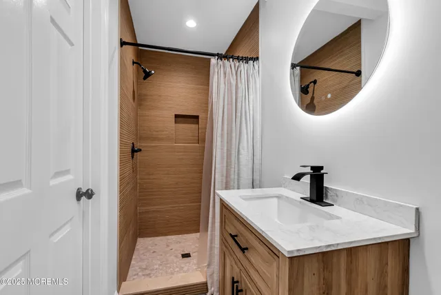 a bathroom with a sink a shower and a mirror
