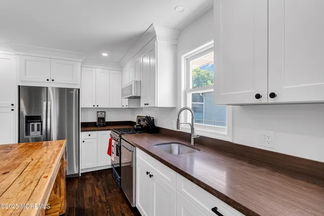 a kitchen with stainless steel appliances granite countertop a sink a stove and refrigerator