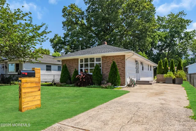 a front view of a house with a yard and trees