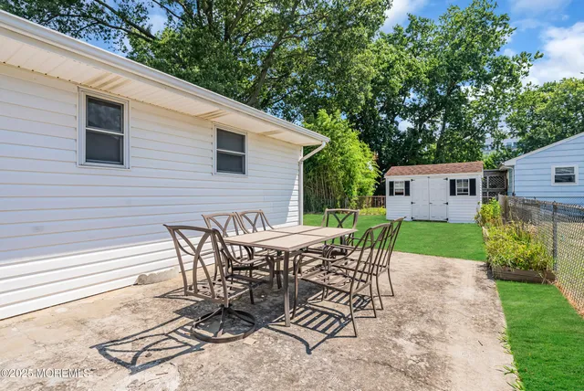 a view of a patio with table and chairs with wooden fence and plants