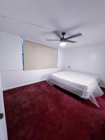 a bedroom with a bed and a ceiling fan