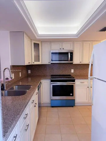a kitchen with stainless steel appliances granite countertop a sink stove and microwave