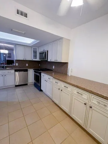 a kitchen with stainless steel appliances granite countertop a sink and cabinets