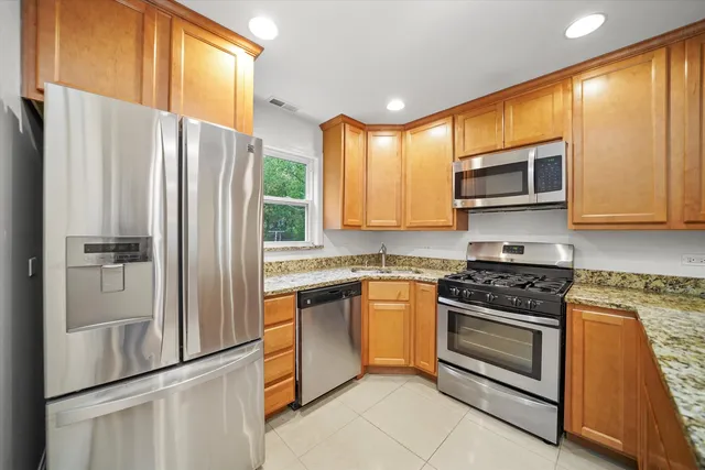 a kitchen with stainless steel appliances granite countertop a refrigerator stove and microwave