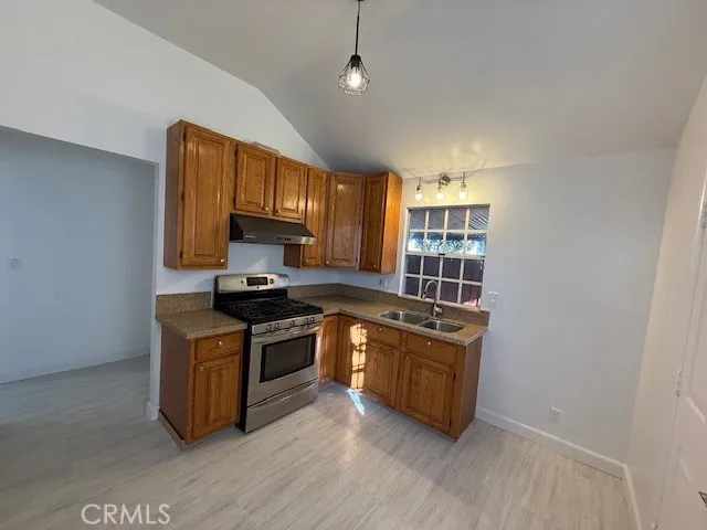 a kitchen with stainless steel appliances granite countertop a stove a sink and a microwave