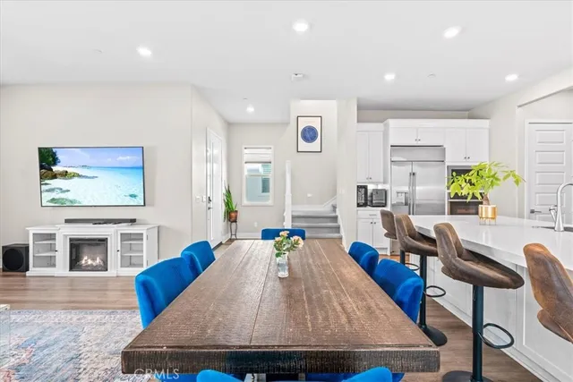 a living room with furniture a flat screen tv and kitchen view