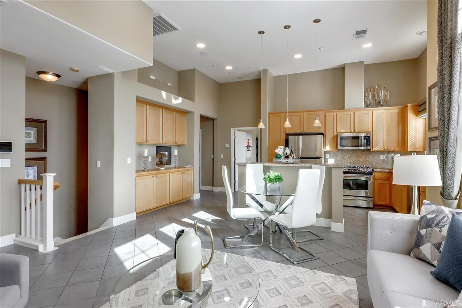 a living room with stainless steel appliances furniture and a view of kitchen
