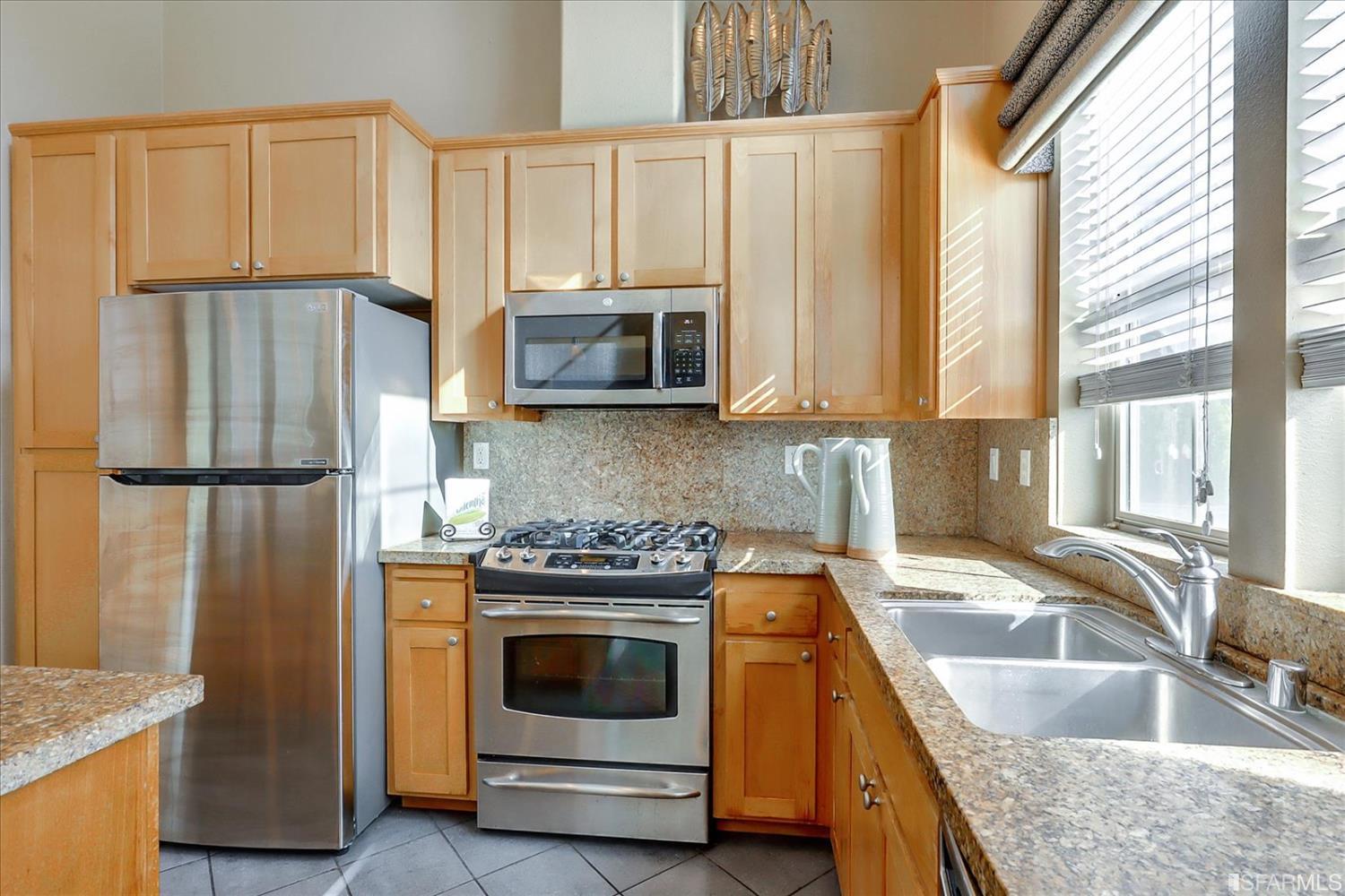 6010 Old Quarry Loop Oakland, CA 94605 - Photo 12 of 32 a kitchen with granite countertop a sink stove and refrigerator