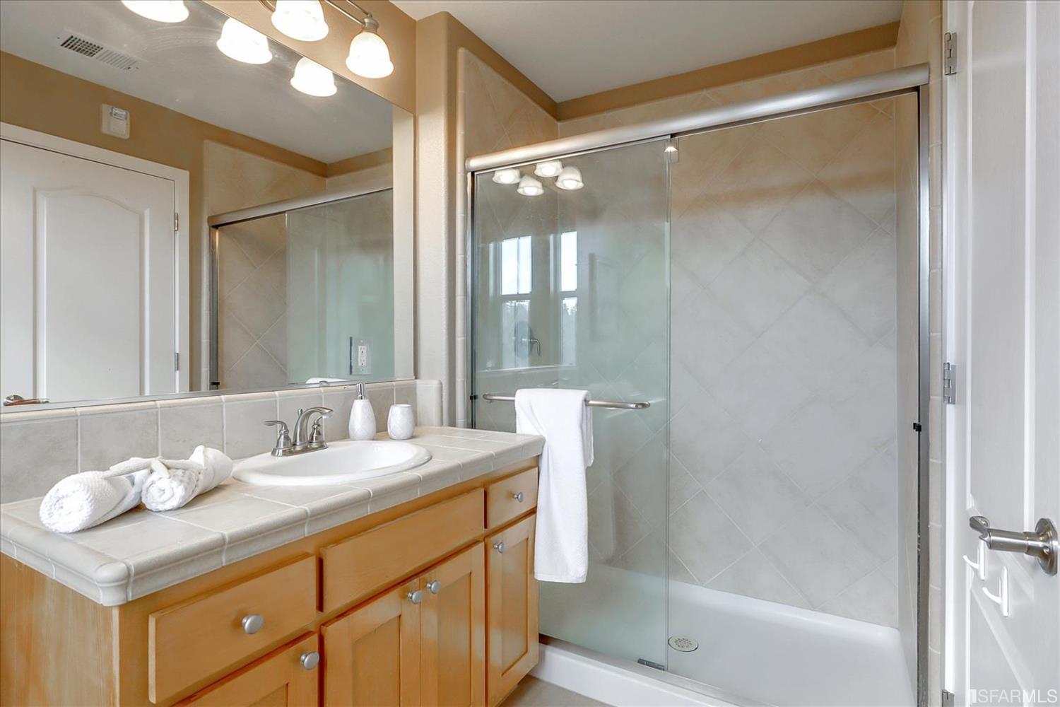 6010 Old Quarry Loop Oakland, CA 94605 - Photo 21 of 32 a bathroom with a sink mirror and a shower