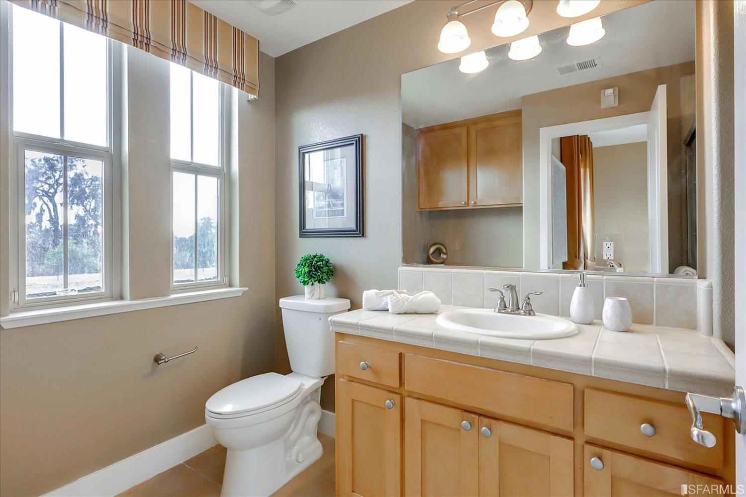 6010 Old Quarry Loop Oakland, CA 94605 - Photo 22 of 32 a bathroom with a granite countertop sink mirror and a toilet
