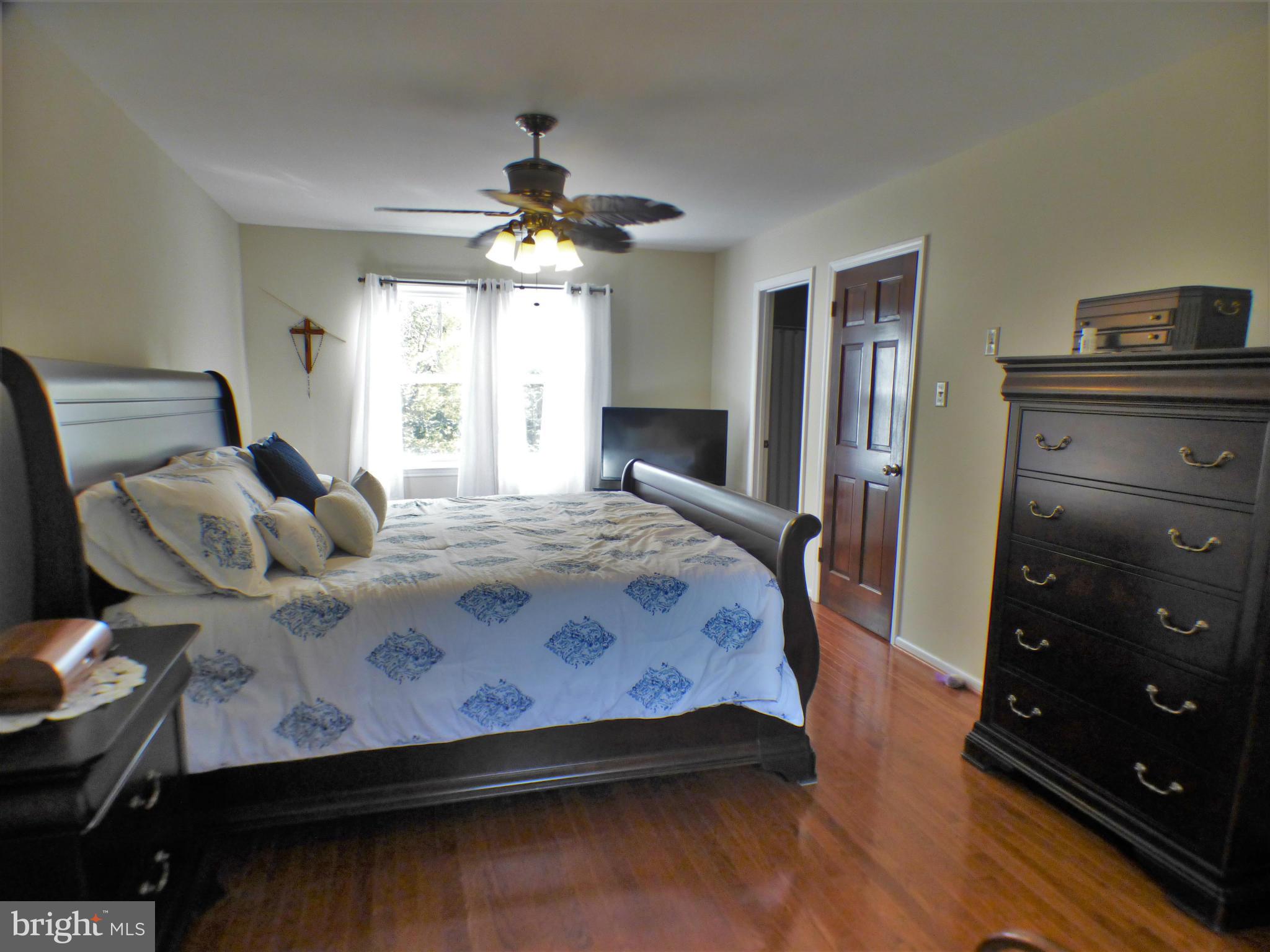 1521 Stinnett Road Huntingtown, MD 20639 - Photo 17 of 30 a bedroom with a bed and a chandelier