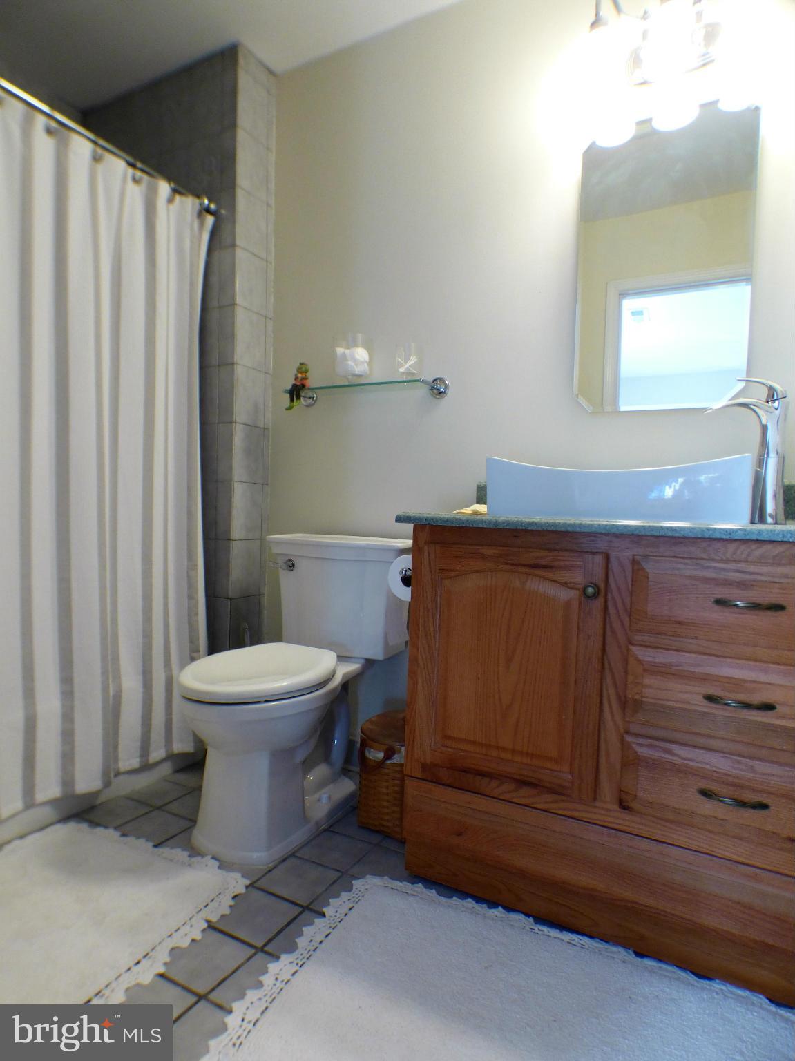 1521 Stinnett Road Huntingtown, MD 20639 - Photo 18 of 30 a bathroom with a toilet a sink and mirror