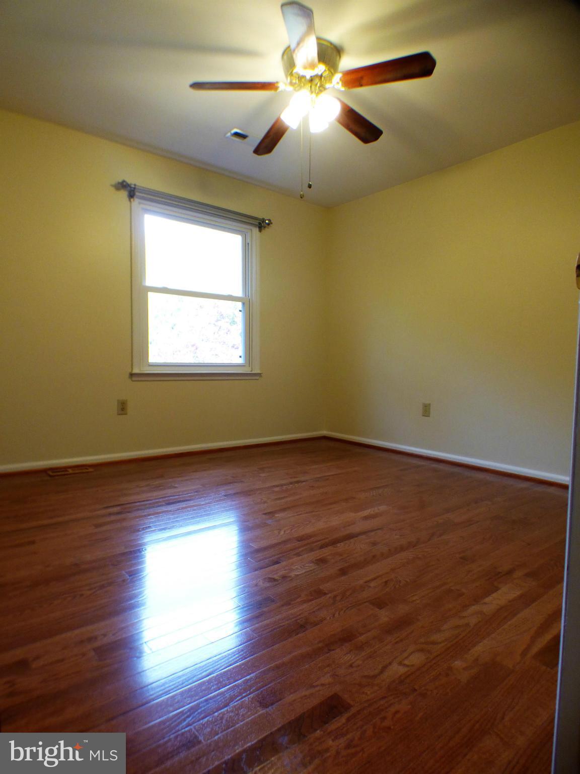 1521 Stinnett Road Huntingtown, MD 20639 - Photo 19 of 30 a view of empty room with wooden floor and fan