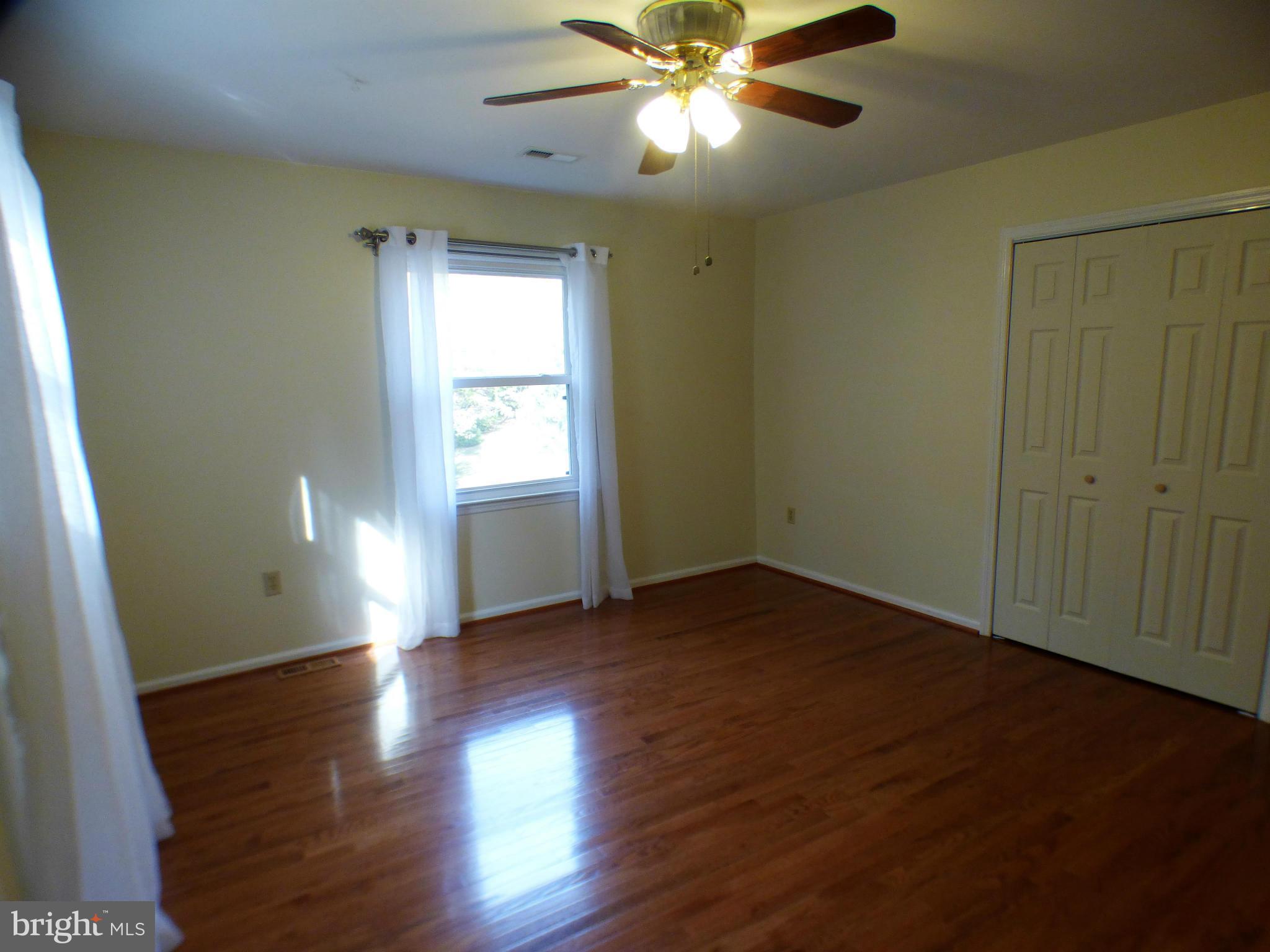 1521 Stinnett Road Huntingtown, MD 20639 - Photo 21 of 30 a view of an empty room with wooden floor and a window